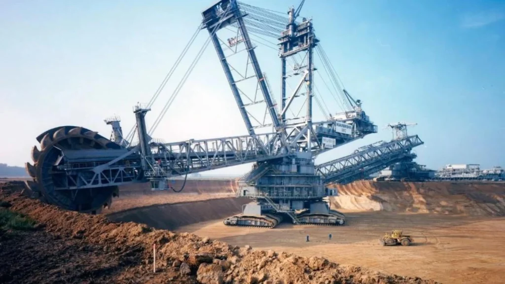 Giant bucket wheel excavator digging in large open-pit mine showing massive mining equipment in operation