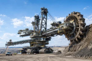 Massive bucket-wheel excavator operating in an open-pit mine, showing extreme scale