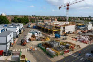 Organised construction site layout with tower crane, material storage and marked traffic routes