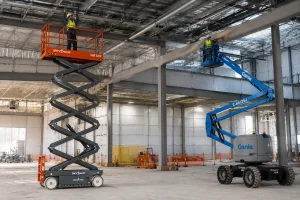 Scissor lift and boom lift operating inside commercial building construction site