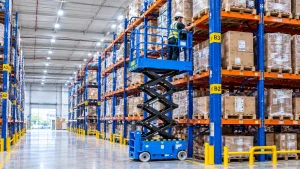 Electric scissor lift operating indoors in a warehouse